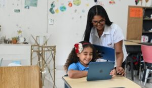 Docente del Colegio De La Salle Santiago acompaña a una estudiante de Nivel Inicial durante una actividad educativa con iPad, fomentando el aprendizaje digital y la creatividad.